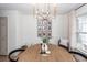 Dining area with chandelier, wood table setting, and decor against a white wall with wood flooring at 122 Moon Shadow Ln, Summerville, SC 29485