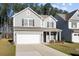 Charming two-story home with gray siding, well-manicured lawn, and a two car attached garage at 128 Surfbird Rd, Summerville, SC 29486