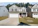 Charming two-story home with gray siding, well-manicured lawn, and a two car attached garage at 128 Surfbird Rd, Summerville, SC 29486