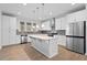 Bright kitchen features white cabinets, stainless appliances, island, and tiled backsplash at 128 Surfbird Rd, Summerville, SC 29486