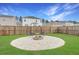 Outdoor fire pit with seating and white gravel surround, enclosed by wood fence and green lawn at 131 Horizon Ridge Dr, Summerville, SC 29486