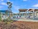 Community pool showcasing blue and white lounge chairs, shaded pergolas, and lush landscaping at 131 Horizon Ridge Dr, Summerville, SC 29486
