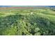 This aerial captures acreage with mature trees and a pond for a picturesque backdrop, perfect for various ventures at 13959 Cottageville Hwy, Cottageville, SC 29435