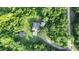 Overhead view of the house and its surroundings, featuring a winding road, a wooded setting and green lawns at 13959 Cottageville Hwy, Cottageville, SC 29435