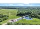 Expansive aerial view showcases property featuring lush green meadows and a serene private pond at 13959 Cottageville Hwy, Cottageville, SC 29435