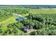 Drone shot features mature landscaping surrounding a main house and a pond on the property at 13959 Cottageville Hwy, Cottageville, SC 29435