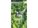 Aerial view of a home surrounded by lush trees, featuring a cozy gazebo, a shed, and a gravel driveway at 13959 Cottageville Hwy, Cottageville, SC 29435
