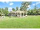 Sprawling property with a covered outdoor area, surrounded by lush greenery and a fenced yard at 13959 Cottageville Hwy, Cottageville, SC 29435