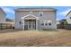 Rear exterior view shows large yard, screened in porch, and neutral color palette at 146 Education Blvd, Ladson, SC 29456