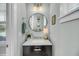 Stylish powder room featuring a circular mirror, marble countertop, and elegant lighting fixtures at 1525 Harriman St, Mount Pleasant, SC 29466