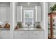 Charming butlers pantry features granite countertops, shaker cabinets, and a window for natural light at 1525 Harriman St, Mount Pleasant, SC 29466