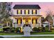 Charming two-story white home with a welcoming front porch, well-manicured landscaping, and warm exterior lighting at twilight at 1525 Harriman St, Mount Pleasant, SC 29466