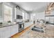 A well-lit kitchen with stainless steel appliances, granite counters, white cabinets, and a stylish sink with a modern faucet at 1525 Harriman St, Mount Pleasant, SC 29466