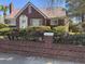 Charming brick home with a metal roof, well-manicured landscaping, and blooming bushes at 161 Gordon Street, Charleston, SC 29403