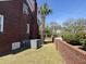 Brick home exterior featuring an air conditioning unit, brick wall, and small lawn at 161 Gordon Street, Charleston, SC 29403