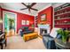 Bright living room with red walls, a fireplace, built-in bookshelves, and comfortable blue sofas at 171 Broad St, Charleston, SC 29401