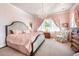 Elegant pink main bedroom with a large bed, chandelier, and bright windows with decorative curtains at 171 Broad St, Charleston, SC 29401