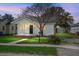 Charming single-story home featuring a welcoming front porch and well-maintained lawn at dusk at 2120 Thornlee Dr, North Charleston, SC 29405