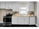 Classic kitchen featuring white cabinetry and black appliances at 2120 Thornlee Dr, North Charleston, SC 29405