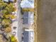 An aerial view shows residences with rooftop decks near sandy land with trees and parking for multiple vehicles at 2135 Tides End Rd, Charleston, SC 29412