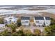 Aerial view showcases modern townhouses nestled among lush trees and marshland scenery at 2135 Tides End Rd, Charleston, SC 29412