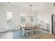 Dining room with rustic wood table, seating for six, decorative lighting, and natural light from the windows at 2135 Tides End Rd, Charleston, SC 29412