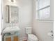 This powder room features a pedestal sink, modern faucet, decorative mirror, and convenient window for natural light at 2135 Tides End Rd, Charleston, SC 29412