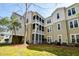 Exterior view of condo, showcasing a screened in balcony and well-maintained lawn at 2434 Egret Crest Ln, Charleston, SC 29414