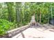 Outdoor stone fireplace with seating area surrounded by mature landscaping and tall palm trees at 2434 Egret Crest Ln, Charleston, SC 29414
