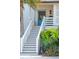 Inviting front entrance with stairs, a blue door, and tropical landscaping at 2529 Atlantic Ave, Sullivans Island, SC 29482