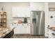 Kitchen featuring white cabinets, a stainless steel refrigerator, and granite countertops for food prep and easy cleanup at 286 Godwit Dr, Summerville, SC 29486