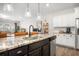 Bright kitchen featuring stainless appliances, white cabinets, granite counters, and an island with seating overlooking the living room at 286 Godwit Dr, Summerville, SC 29486