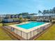 Community pool featuring lounge chairs and a secure fence surrounded by lush lawns and beautiful single Gathering homes at 286 Godwit Dr, Summerville, SC 29486