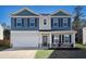 Inviting two-story home showcasing blue and beige siding, complemented by a well-manicured lawn and attached garage at 294 Torslanda Ln, Summerville, SC 29486