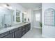 Bathroom featuring double sinks, granite countertops, and a decorative window frame, enhancing its aesthetic appeal at 312 Coki Amalie Ct, Charleston, SC 29492