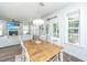 Bright dining area open to living room with wood table, white chairs, and natural light at 312 Coki Amalie Ct, Charleston, SC 29492