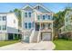 Charming two-story home features a welcoming porch, double garages, and manicured front yard at 312 Coki Amalie Ct, Charleston, SC 29492