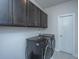 Modern laundry room featuring dark cabinetry, a tiled floor, and a side-by-side washer and dryer at 312 Coki Amalie Ct, Charleston, SC 29492