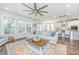 Open living space with plush sofa, modern ceiling fan, and large windows providing natural light at 312 Coki Amalie Ct, Charleston, SC 29492