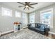 Cozy living room with windows, a ceiling fan, a black leather couch, and shelving at 312 Coki Amalie Ct, Charleston, SC 29492