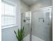 Tiled shower with glass doors, a built-in niche, and a green plant, adding a touch of nature to the bathroom at 312 Coki Amalie Ct, Charleston, SC 29492