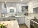 Bright kitchen with white cabinets, marble countertops, modern appliances and open shelving at 330 Concord St # 11D, Charleston, SC 29401