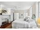 Bright bedroom with fireplace, custom closet, white bedding and ensuite bathroom at 34 Anson St, Charleston, SC 29401