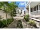Beautiful brick driveway leading to a white carriage house, framed by lush greenery at 34 Anson St, Charleston, SC 29401