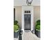 Elegant front door with decorative molding, flanked by manicured greenery and vintage lanterns at 34 Anson St, Charleston, SC 29401