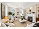 Bright living room with a fireplace, chandelier, large windows and neutral colored furniture at 34 Anson St, Charleston, SC 29401