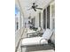 Relaxing outdoor porch with white columns, chaise lounges, ceiling fans and a neighborhood view at 34 Anson St, Charleston, SC 29401