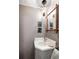 Cozy powder room with unique wallpaper, bamboo framed mirror, and a marble countertop sink at 34 Anson St, Charleston, SC 29401