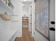 A mud room with white walls, bench, shelves, hooks and a door with a blind at 3785 Summerton St, Mount Pleasant, SC 29466