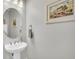Well-lit powder room with a pedestal sink, decorative mirror, and charming wall art at 4603 Scout Aly, North Charleston, SC 29405